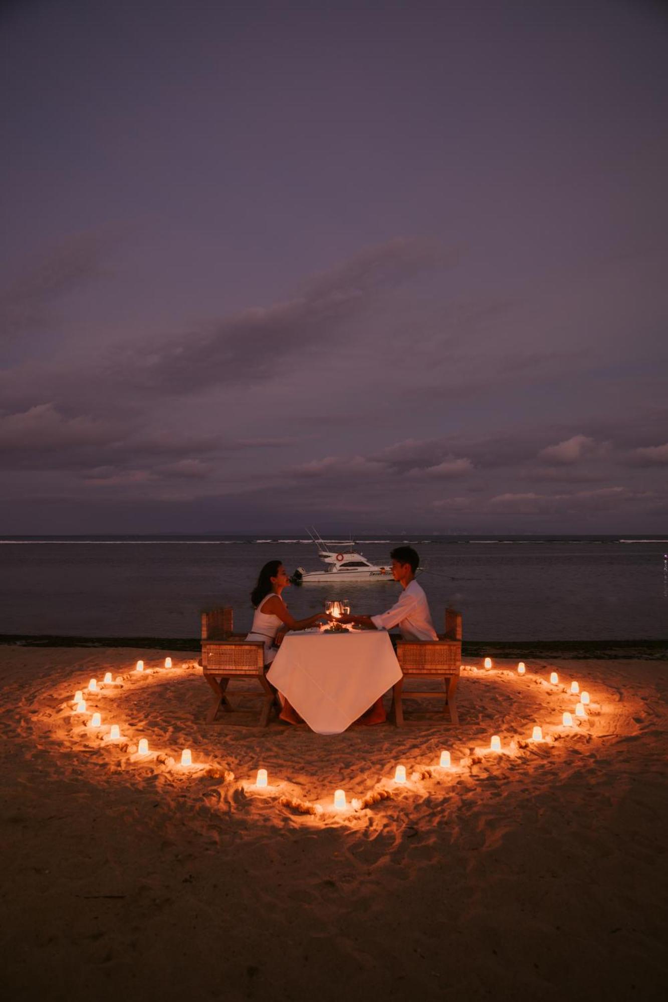 صدارة بوتيك بيتش ريزورت نوسا دوا المظهر الخارجي الصورة A couple dining on a beach at night